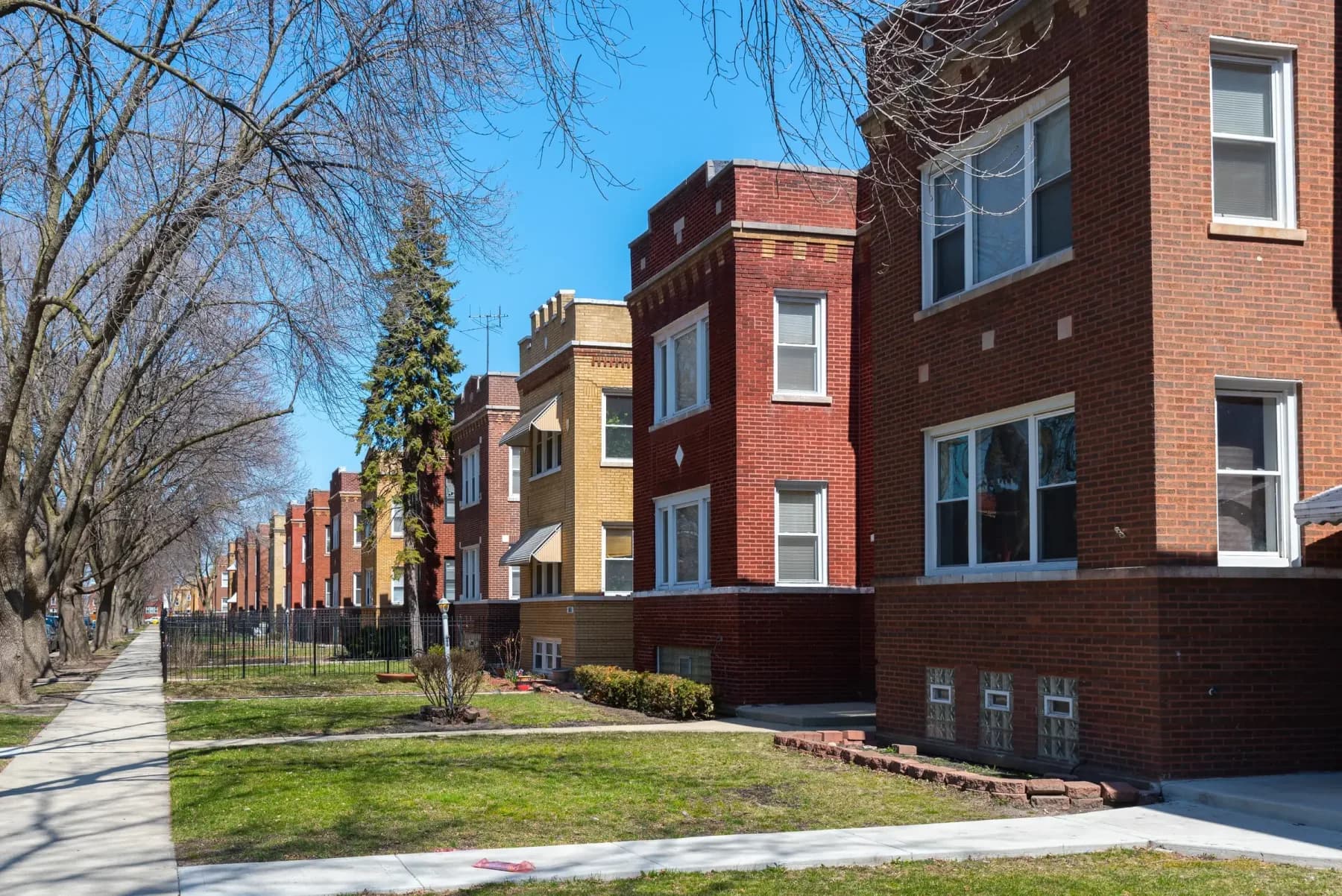 Brick two-flats and apartment buildings along a Chicago street